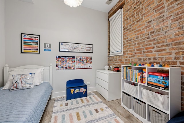1423 N Ashland Ave Unit 201, Chicago, IL 60622 - bedroom with light wood-style floors and brick wall