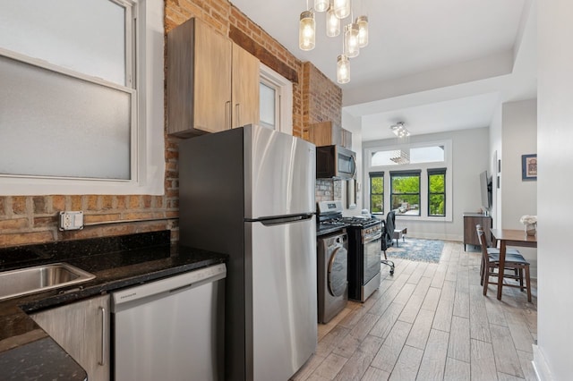1423 N Ashland Ave Unit 201, Chicago, IL 60622 - kitchen featuring appliances with stainless steel finishes, light wood-style floors, dark stone counters, decorative light fixtures, and a chandelier