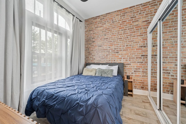 1423 N Ashland Ave Unit 201, Chicago, IL 60622 - bedroom featuring light wood-style flooring and brick wall