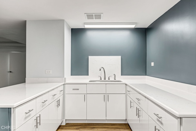 3150 N Lake Shore Dr Unit 29F, Chicago, IL 60657 - kitchen featuring light countertops, white cabinets, a peninsula, and wood finished floors