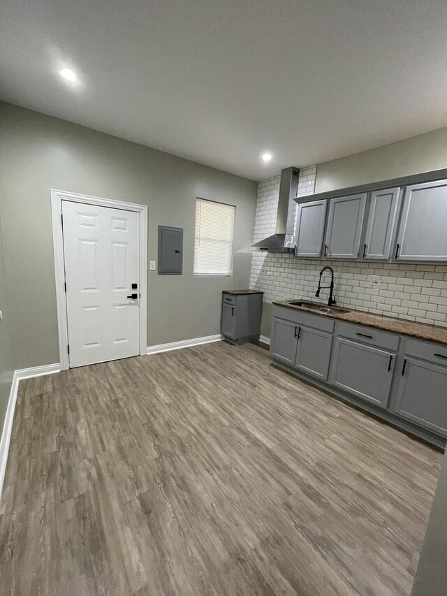 6239 S Bishop St, Chicago, IL 60636 - kitchen with wall chimney range hood, gray cabinetry, electric panel, backsplash, and light wood finished floors