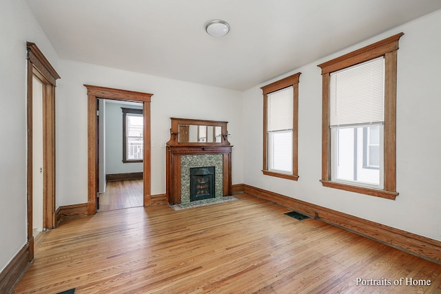 127 N W St, Wheaton, IL 60187 - unfurnished living room with healthy amount of natural light, a fireplace with flush hearth, and light wood-style flooring