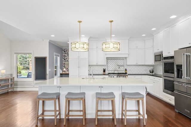 13616 S Erin Dr, Homer Glen, IL 60491 - kitchen with appliances with stainless steel finishes, backsplash, white cabinetry, a kitchen bar, and recessed lighting