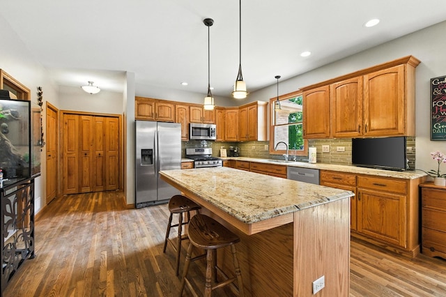 14N924 White Pines Ln, Hampshire, IL 60140 - kitchen with stainless steel appliances, wood finished floors, tasteful backsplash, a kitchen island, and a breakfast bar