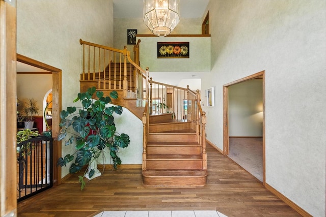 14N924 White Pines Ln, Hampshire, IL 60140 - stairs featuring wood finished floors, a high ceiling, and a chandelier