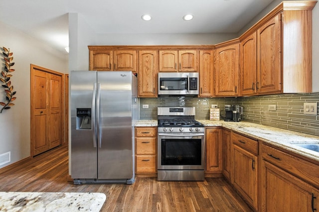 14N924 White Pines Ln, Hampshire, IL 60140 - kitchen with stainless steel appliances, light stone counters, dark wood finished floors, decorative backsplash, and brown cabinetry