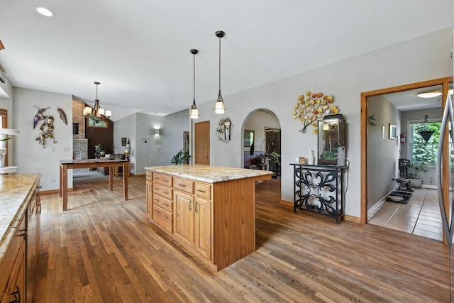 14N924 White Pines Ln, Hampshire, IL 60140 - kitchen with arched walkways, wood finished floors, hanging light fixtures, a chandelier, and a kitchen island