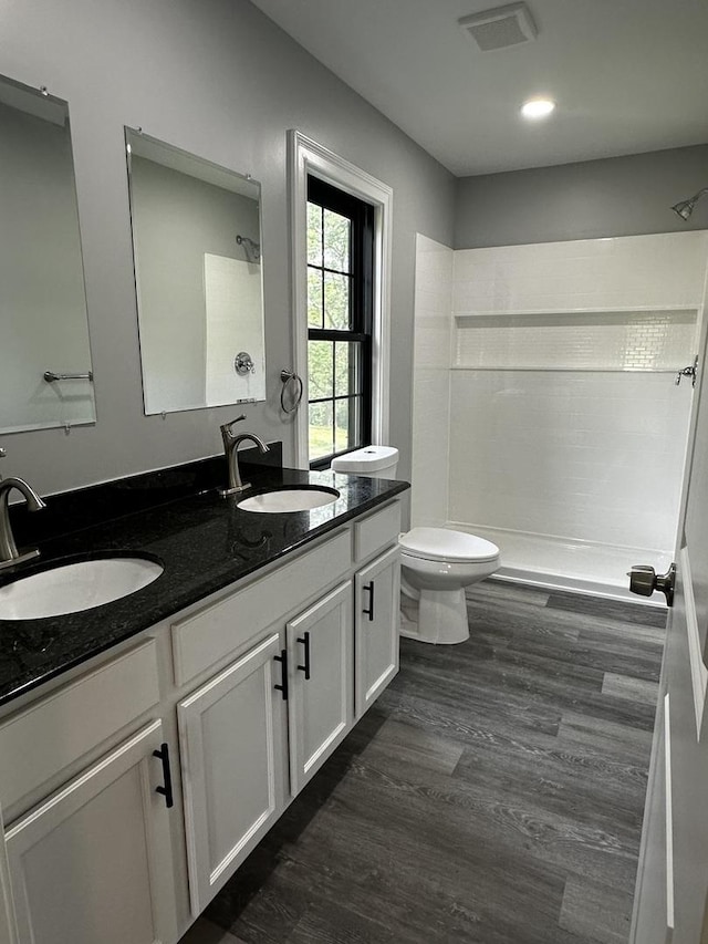 2212 N 2829th Rd, Marseilles, IL 61341 - bathroom featuring tiled shower, double vanity, wood finished floors, and recessed lighting