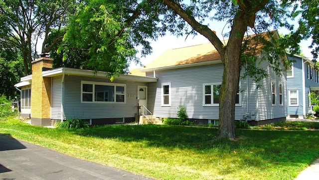 459 Talma St, Aurora, IL 60505 - view of front of house with entry steps, a chimney, and a front yard