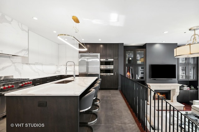 417 E N Water St, Chicago, IL 60611 - kitchen with high end appliances, modern cabinets, an island with sink, decorative backsplash, and hanging light fixtures