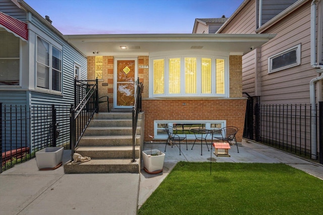 2317 W 50th St, Chicago, IL 60609 - exterior entry at dusk featuring brick siding and a patio