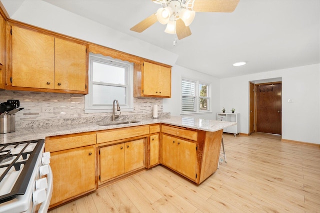 2317 W 50th St, Chicago, IL 60609 - kitchen with a peninsula, white range with gas stovetop, backsplash, light wood-style floors, and recessed lighting