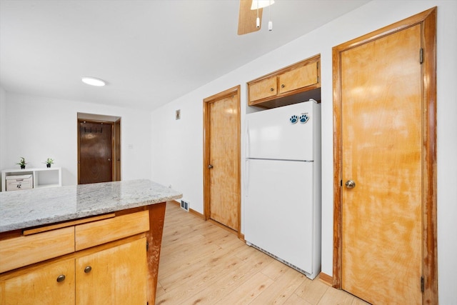 2317 W 50th St, Chicago, IL 60609 - kitchen with freestanding refrigerator, light wood-style floors, and light stone countertops