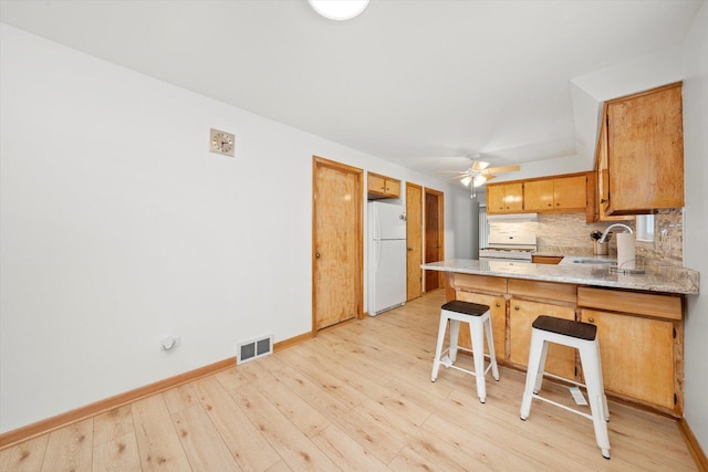 2317 W 50th St, Chicago, IL 60609 - kitchen with freestanding refrigerator, a peninsula, ceiling fan, light wood-type flooring, and tasteful backsplash
