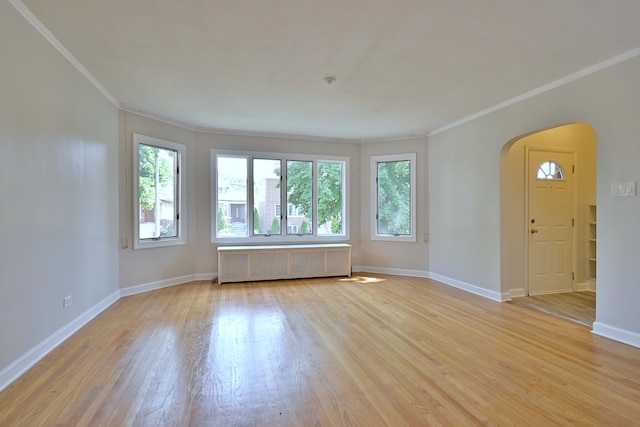 7851 W Cressett Dr, Elmwood Park, IL 60707 - unfurnished room with radiator, arched walkways, ornamental molding, and light wood-style floors