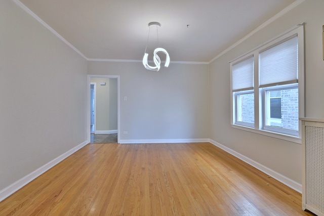 7851 W Cressett Dr, Elmwood Park, IL 60707 - spare room featuring ornamental molding, light wood-style flooring, and a chandelier