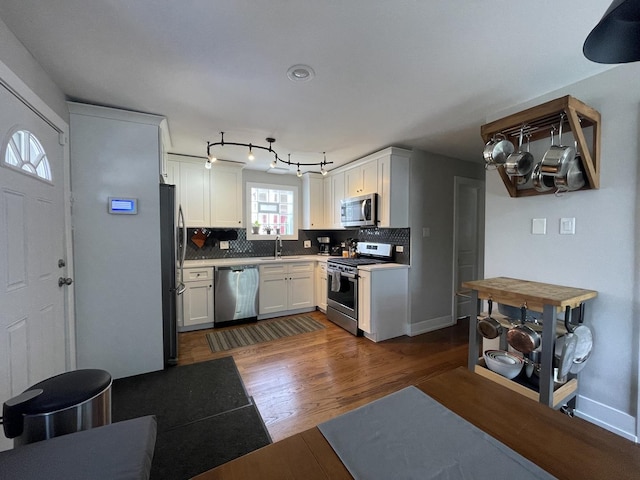 3401 W Beach Ave, Chicago, IL 60651 - kitchen with appliances with stainless steel finishes, tasteful backsplash, dark wood finished floors, white cabinets, and light countertops