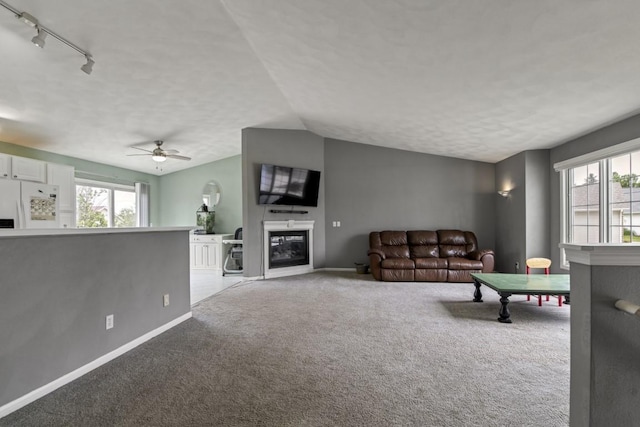 6072 Nimtz Ct, Loves Park, IL 61111 - living area with a glass covered fireplace, carpet floors, track lighting, plenty of natural light, and lofted ceiling
