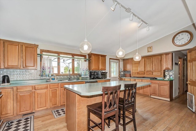 944 E County Line Rd, Beecher, IL 60401 - kitchen featuring a breakfast bar, lofted ceiling, decorative backsplash, rail lighting, and a center island