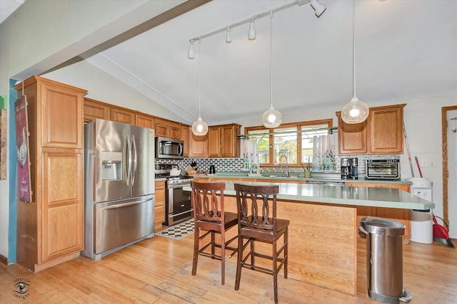 944 E County Line Rd, Beecher, IL 60401 - kitchen featuring stainless steel appliances, decorative backsplash, a breakfast bar area, light wood-style flooring, and light countertops