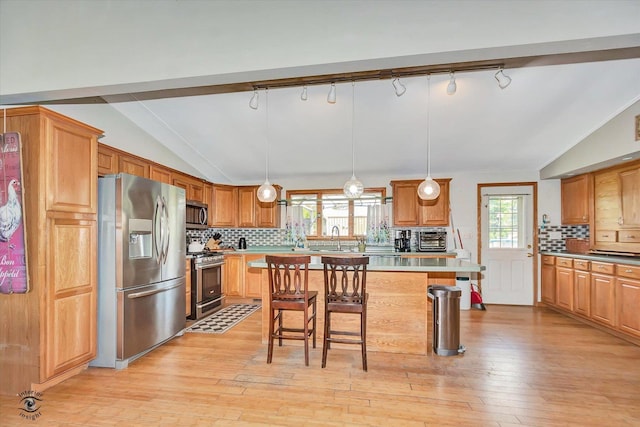 944 E County Line Rd, Beecher, IL 60401 - kitchen with appliances with stainless steel finishes, vaulted ceiling, a breakfast bar area, healthy amount of natural light, and backsplash