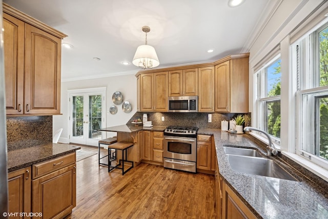 4628 Grand Ave, Western Springs, IL 60558 - kitchen featuring appliances with stainless steel finishes, crown molding, healthy amount of natural light, french doors, and light wood finished floors