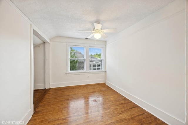 4628 Grand Ave, Western Springs, IL 60558 - unfurnished bedroom featuring a textured ceiling, lofted ceiling, wood finished floors, a closet, and a ceiling fan