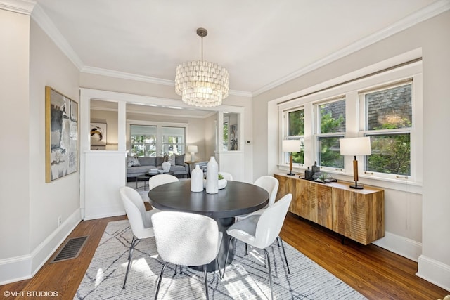 4628 Grand Ave, Western Springs, IL 60558 - dining space with a chandelier, dark wood-style floors, ornamental molding, and healthy amount of natural light
