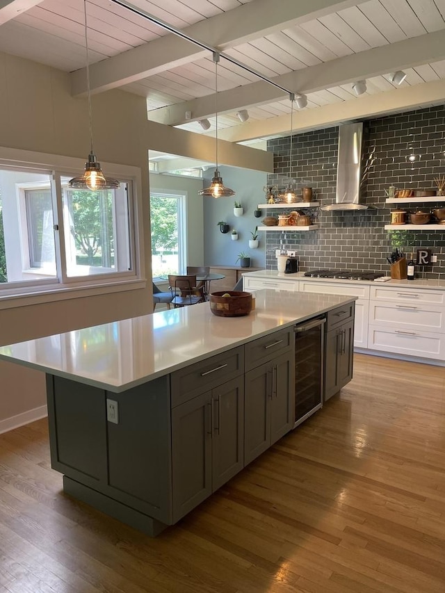 743 Dundee Ave, Barrington, IL 60010 - kitchen with beverage cooler, wall chimney range hood, gas stovetop, light wood-style floors, and a kitchen island