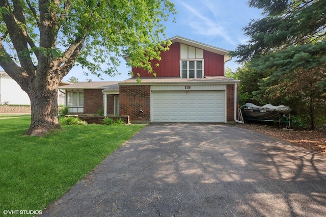 view of front facade with asphalt driveway, a front yard, an attached garage, and brick siding