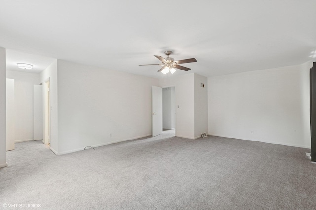 carpeted spare room with a ceiling fan