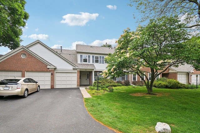 1604 Brittany Ct Unit 2B, Wheeling, IL 60090 - traditional home with brick siding, a front lawn, an attached garage, and asphalt driveway