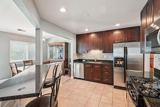 1604 Brittany Ct Unit 2B, Wheeling, IL 60090 - kitchen with stainless steel appliances, tasteful backsplash, dark stone countertops, recessed lighting, and light tile patterned flooring