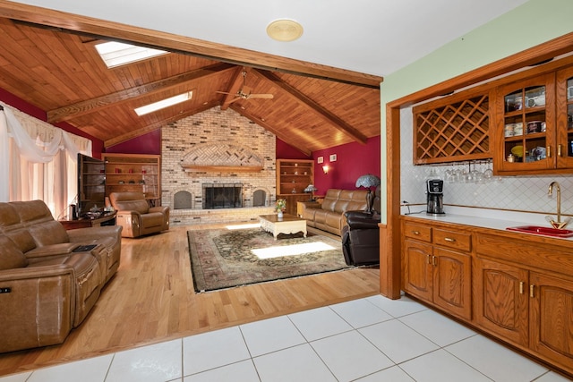 24029 S Plum Valley Dr, Crete, IL 60417 - living area featuring wood ceiling, light tile patterned floors, a skylight, ceiling fan, and a fireplace