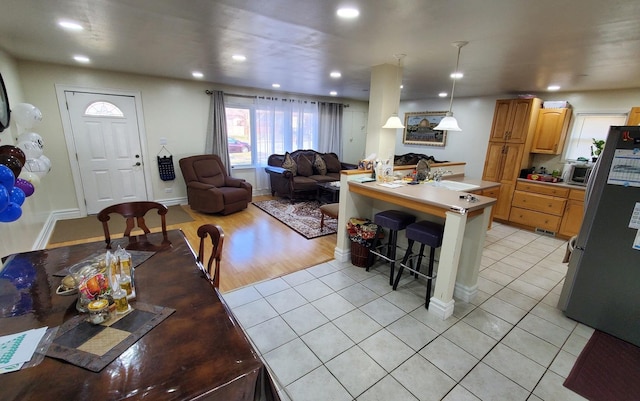 17936 66th Ave, Tinley Park, IL 60477 - kitchen with appliances with stainless steel finishes, a kitchen bar, open floor plan, light tile patterned floors, and light countertops