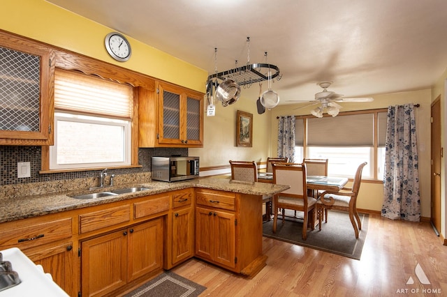 7707 Moody Ave, Burbank, IL 60459 - kitchen featuring stainless steel microwave, brown cabinetry, tasteful backsplash, and a ceiling fan