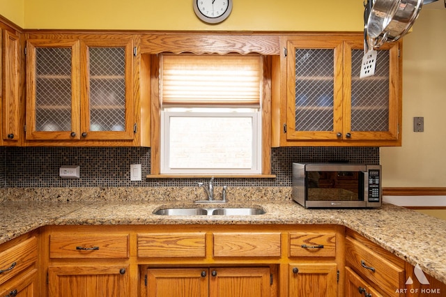7707 Moody Ave, Burbank, IL 60459 - kitchen with stainless steel microwave, decorative backsplash, glass insert cabinets, and light stone countertops