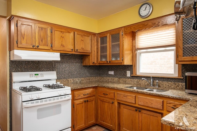 7707 Moody Ave, Burbank, IL 60459 - kitchen with white range with gas stovetop, under cabinet range hood, brown cabinets, and backsplash