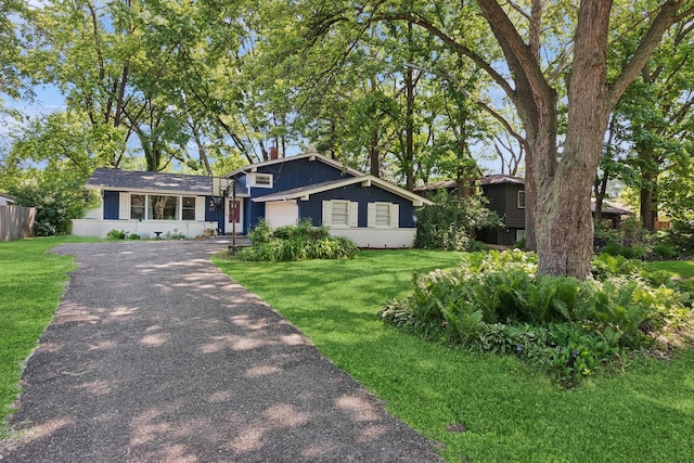 view of front facade featuring a garage, driveway, and a chimney