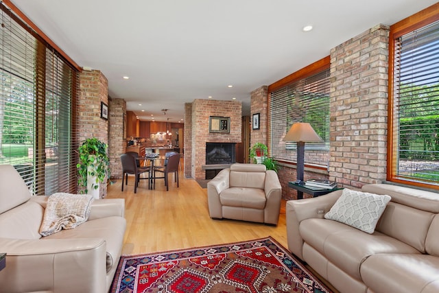 1200 Regency Ln, Lake Forest, IL 60045 - living area featuring brick wall, plenty of natural light, wood finished floors, a brick fireplace, and recessed lighting