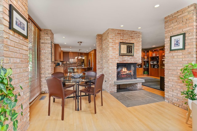 1200 Regency Ln, Lake Forest, IL 60045 - dining space featuring a brick fireplace, recessed lighting, light wood finished floors, and brick wall