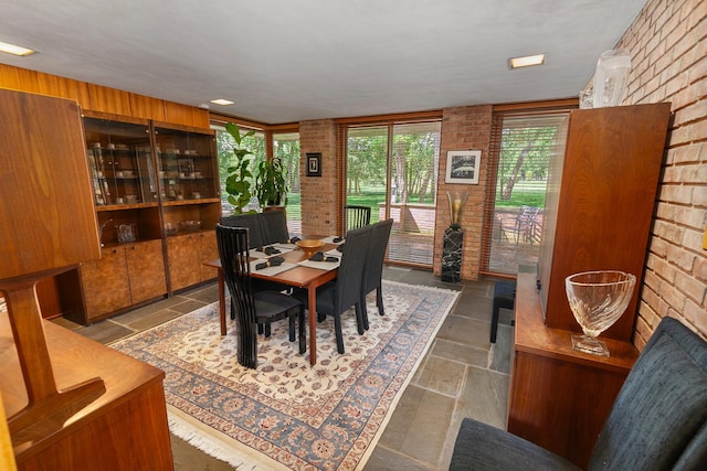 1200 Regency Ln, Lake Forest, IL 60045 - dining room featuring brick wall, plenty of natural light, and stone tile floors