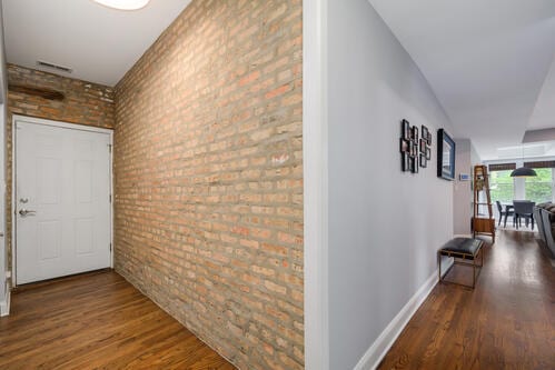 4259 N Ashland Ave Unit 2, Chicago, IL 60613 - corridor featuring wood finished floors and brick wall