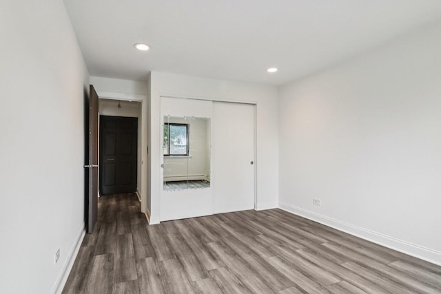 5525 N Chester Ave Unit 46, Chicago, IL 60656 - unfurnished bedroom with wood finished floors, a baseboard heating unit, a closet, and recessed lighting