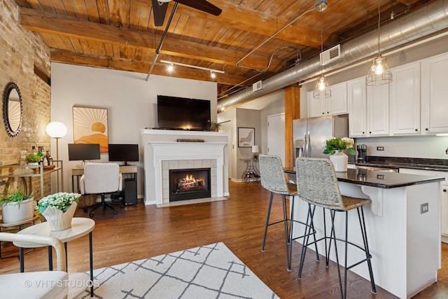 1740 N Maplewood Ave Unit 416, Chicago, IL 60647 - kitchen featuring a wooden ceiling with exposed beams, dark wood finished floors, dark countertops, white cabinetry, and a breakfast bar