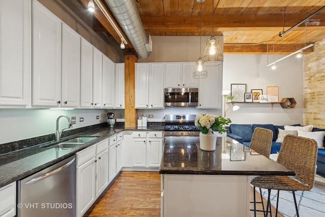 1740 N Maplewood Ave Unit 416, Chicago, IL 60647 - kitchen with stainless steel appliances, light wood finished floors, white cabinetry, a wood ceiling with exposed beams, and dark stone countertops