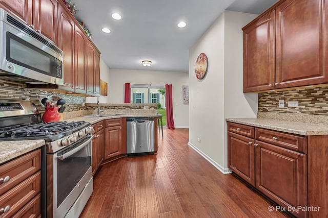 392 S Jade Ln, Round Lake, IL 60073 - kitchen with appliances with stainless steel finishes, dark wood finished floors, decorative backsplash, recessed lighting, and a peninsula