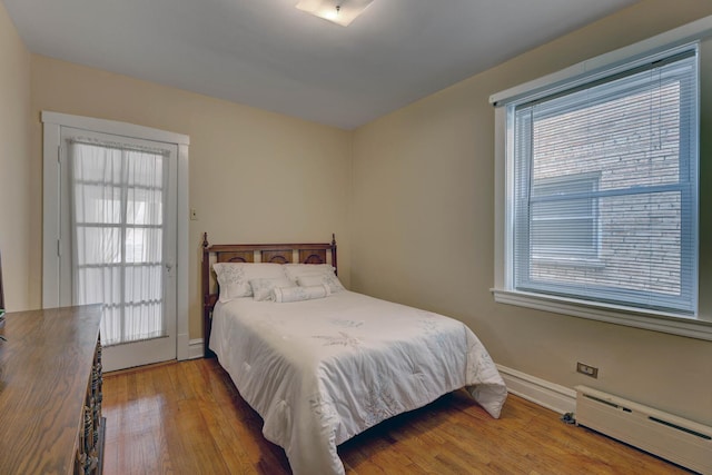 4934 N Marmora Ave, Chicago, IL 60630 - bedroom with a baseboard heating unit, wood finished floors, and multiple windows