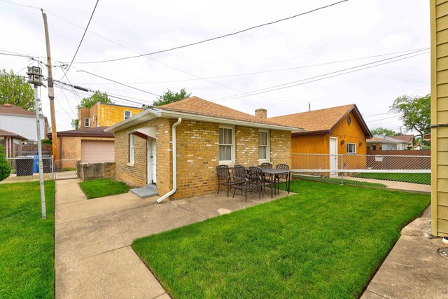 4934 N Marmora Ave, Chicago, IL 60630 - back of house with brick siding, a fenced backyard, a patio, and a chimney