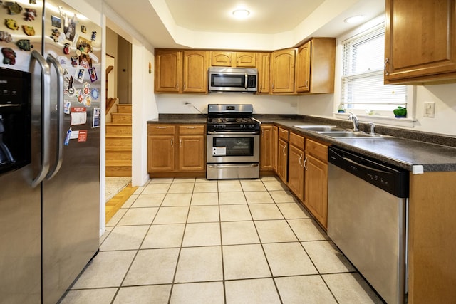 1065 Irwin Ave, Des Plaines, IL 60018 - kitchen with stainless steel appliances, brown cabinetry, dark countertops, and light tile patterned floors